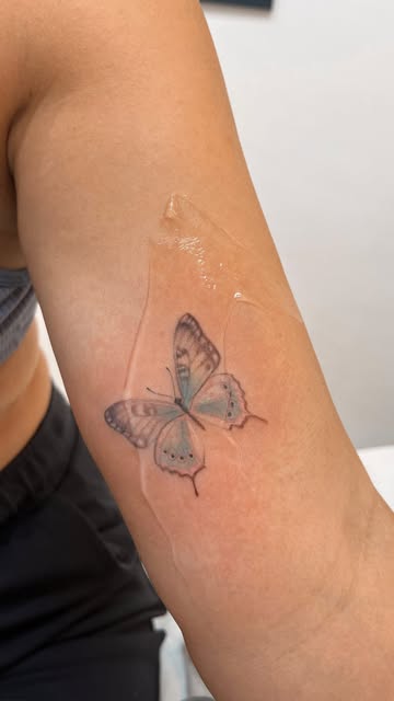 Tatuaje de mariposa con toques de color