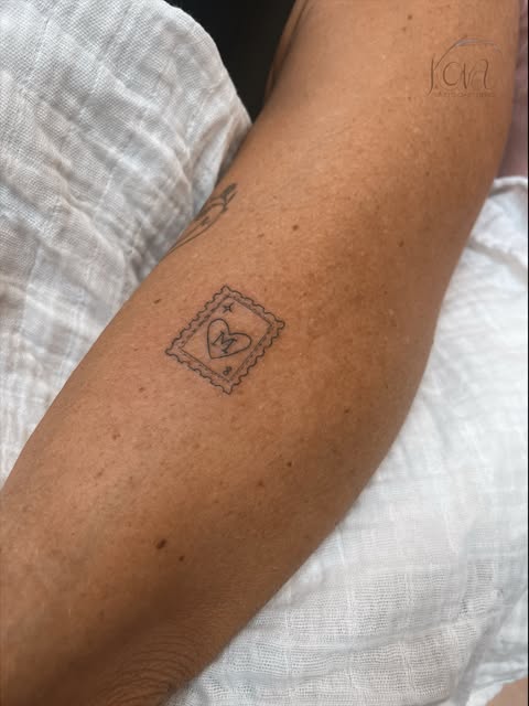 Tatuaje de sello con corazón e inicial